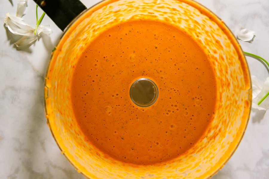 A food processor bowl with red pepper aioli in it. 
