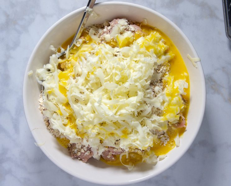 Bowl of turkey meat with egg, butter, and oats on topv